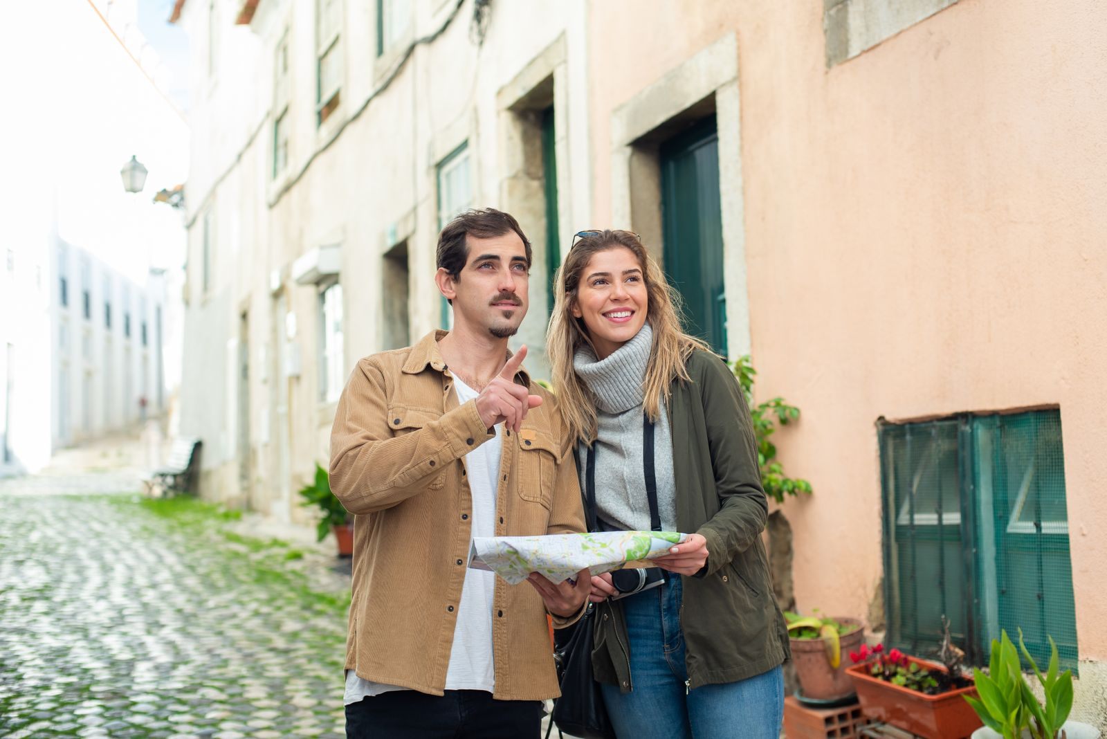 Couple with a map exploring a cobbled old-town street on a stop that shows Danube river cruises are safe and walkable
